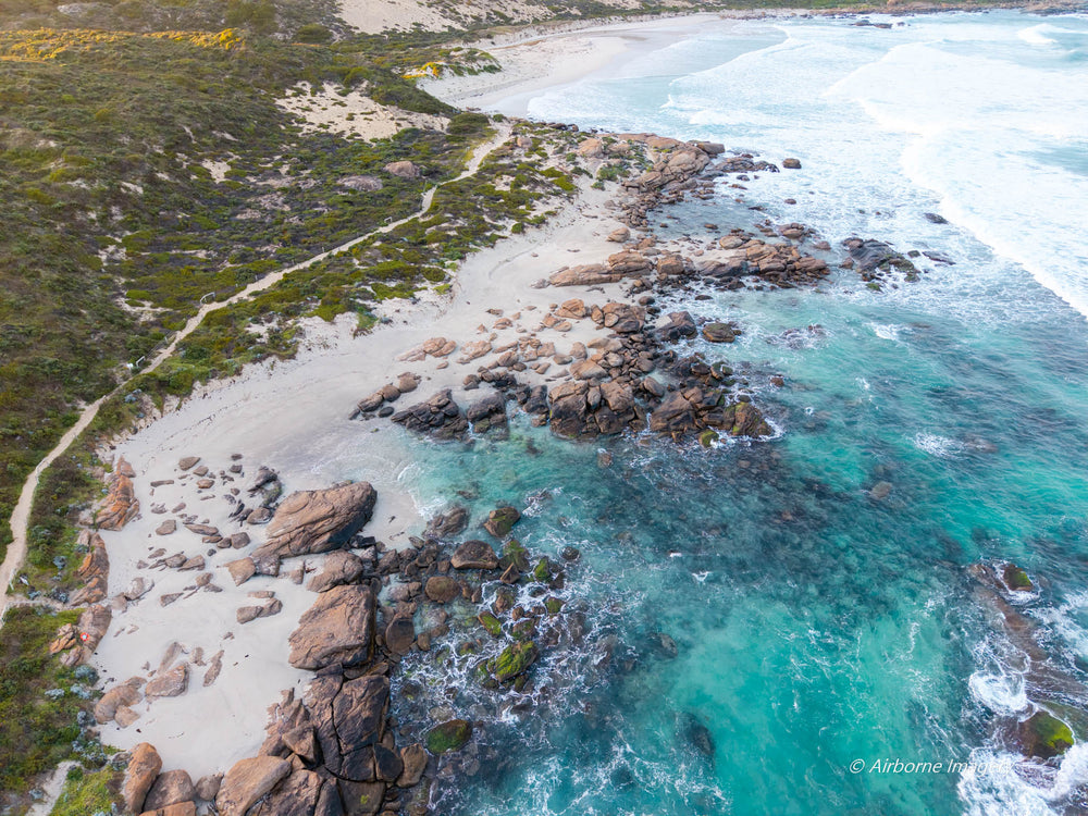 Aerial view of Redgate Beach, Margaret River, featuring turquoise ocean, rocky reef, white sand and the rugged South West WA coastline.