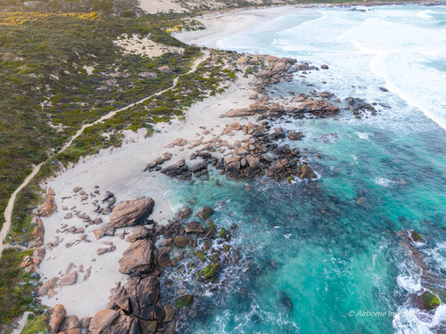 Aerial view of Redgate Beach, Margaret River, featuring turquoise ocean, rocky reef, white sand and the rugged South West WA coastline.