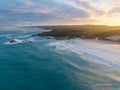 Aerial view of Redgate Beach, Margaret River at sunrise, with golden morning light, turquoise ocean, rolling waves and rugged South West WA coastline.
