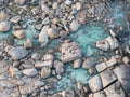 Aerial view of turquoise water weaving through rugged granite boulders at Redgate Beach, Margaret River, Western Australia.