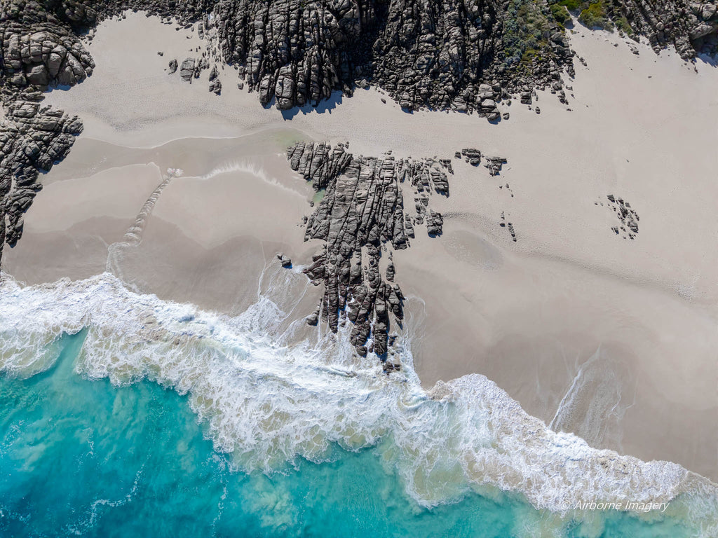 Overhead aerial view of Injidup Beach in Yallingup, with white sand meeting rolling turquoise water and foamy white waves.
